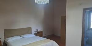 ein Schlafzimmer mit einem weißen Bett und einem Kronleuchter in der Unterkunft Quattro stagioni appartamento Inverno in Castiglione del Lago