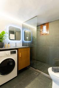 a bathroom with a washing machine and a shower at MD Horizon with private Jacuzzi near the beach in Anissaras