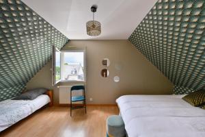 a bedroom with two beds and a window at La Maison d'Herbignac - Grand Jardin in Herbignac