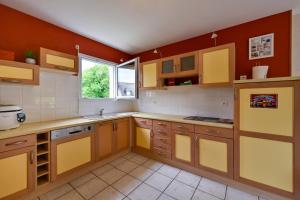 a large kitchen with yellow cabinets and a window at La Maison d'Herbignac - Grand Jardin in Herbignac +7 photos