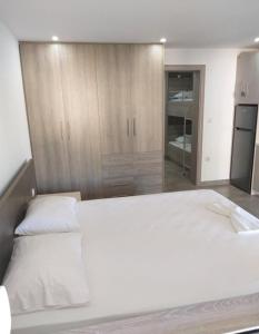 a bedroom with a large white bed and wooden cabinets at Villa Morena in Mursi