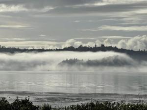 Blick auf ein Gewässer mit Nebel auf dem Wasser in der Unterkunft Auckland Luxury Seafront House in Auckland