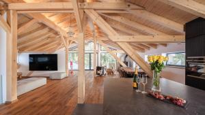 グレヘンにあるLuxury chalet with panoramic views, sauna, hot tub & cinemaの木製の天井とテレビが備わる広いリビングルーム