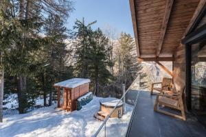 グレヘンにあるLuxury chalet with panoramic views, sauna, hot tub & cinemaの雪の中の小屋の網戸付きポーチ