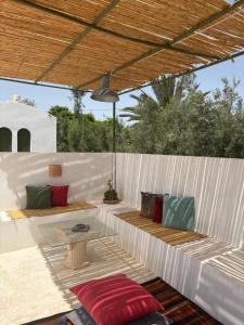 a patio with a couch and a table at Djerba houch in El Mây