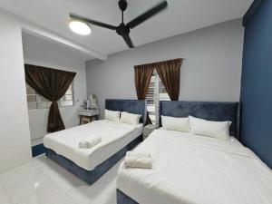 a bedroom with two beds and a blue wall at W907WarmStay at EmeraldAvenueBrinchang in Brinchang