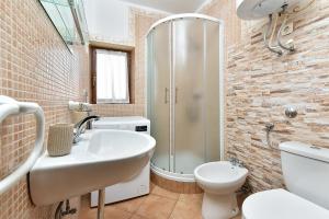 a bathroom with a sink and a toilet and a shower at Apartments Suzi 2381 in Peroj +15 photos