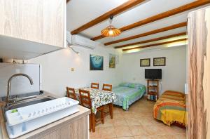 a kitchen with a sink and a room with a table at Apartments Suzi 2381 in Peroj