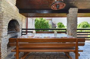 a wooden bench sitting on a patio with a fireplace at Apartments Suzi 2381 in Peroj