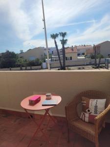 a table and two chairs on a balcony with a table and a coffeeucer at Le studio 29 in Le Barcarès +10 photos