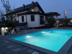 a large blue swimming pool in front of a house at Villa Aldina Apartment 2 in Bihać