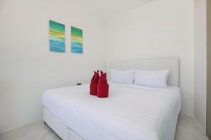 a white bed with a pair of red shoes on it at Sea View Apartment A32 in Kamala Ocean Residence just 450m from Kamala Beach in Kamala Beach +17 photos