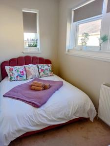 a bedroom with a bed with a purple blanket at The Bunker, Golf Cottage in Prestwick