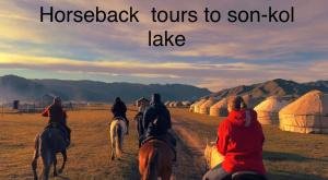 a group of people riding horses in a field at Nomad Guest House in Kochkorka