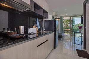 a kitchen with a refrigerator and a counter top at Sea View Apartment A32 in Kamala Ocean Residence just 450m from Kamala Beach in Kamala Beach