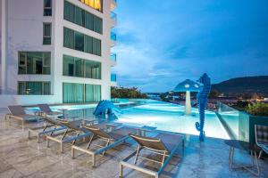 a hotel patio with chairs and a swimming pool at Sea View Apartment A32 in Kamala Ocean Residence just 450m from Kamala Beach in Kamala Beach