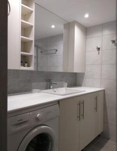 a bathroom with a washing machine and a sink at Villa Morena in Mursi +8 photos