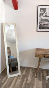 a mirror in a room with a chair and a table at Lederkappe Apartments in Mühlhausen +30 photos