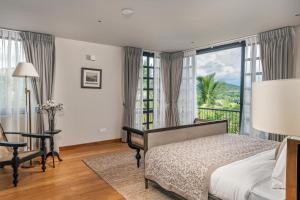 a bedroom with a bed and a desk and a window at The Alfred Digana by The One Group of Hotels in Digana