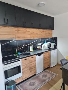 a kitchen with white appliances and wooden cabinets at Be POZITIVE in Sombor
