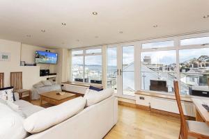 Una sala de estar con un sofá blanco y una ventana grande. en Upper Anzac Sea View Retreat with Roof Terrace in Central Brixham, en Brixham