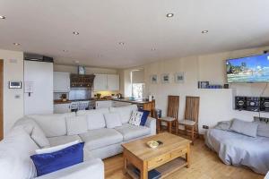 una sala de estar con un sofá y una mesa en Upper Anzac Sea View Retreat with Roof Terrace in Central Brixham, en Brixham 9 fotos más