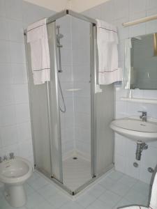 ein Bad mit einer Dusche, einem WC und einem Waschbecken in der Unterkunft Hotel Garnì Capinera in Garda