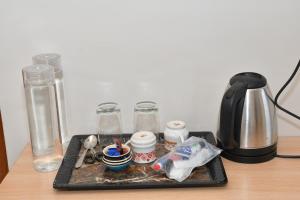 a tray with a coffee maker and other items on a table at Kandhan Kudil in Virudunagar