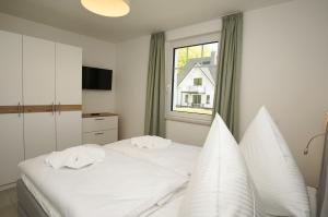 En eller flere senge i et værelse på Rex Rugia FeWo15-4 mit Schwimmbad und Saunanutzung im AHOI-Erlebnisbad Sellin