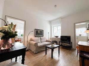 Una sala de estar con un sofá y un televisor. en Haus Friesland - Wohnung 5, en Westerland