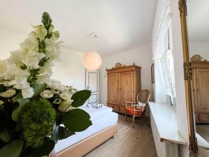 Un dormitorio con una cama con flores blancas. en Haus Friesland - Wohnung 5, en Westerland