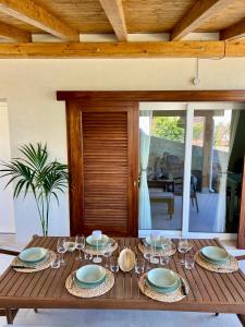 a wooden table with plates and wine glasses on it at Villa Anthea - Relax vista mare tra Palermo e Cefalù in Trabia