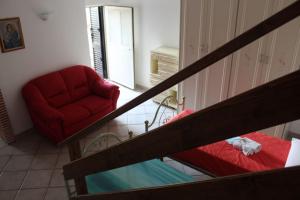 a living room with a red couch and a chair at La Casa nel Sole Poggio Bustone in Poggio Bustone