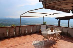 a patio with two chairs and a table and an umbrella at La Casa nel Sole Poggio Bustone in Poggio Bustone