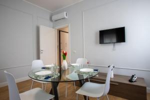 Un comedor con una mesa de cristal y sillas blancas. en Misultin - 10 minuti dal centro, en Como