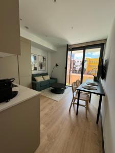 Una cocina y una sala de estar con una mesa y un sofá. en Oasis Pavia 15, en Las Palmas de Gran Canaria