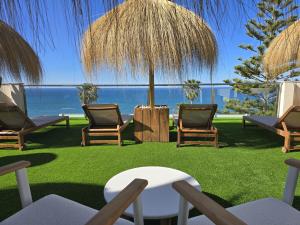 patio z krzesłami i stołem oraz widokiem na ocean w obiekcie As Apartamentos Turisticos w mieście Morche