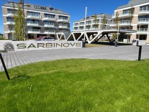 Un cartel en el césped frente a un edificio. en Sarbinowe Morska Bryza, en Sarbinowo 11 fotos más