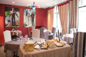 a dining room with a table with food on it at Hôtel et Restaurant Le Regina in Le Puy-en-Velay