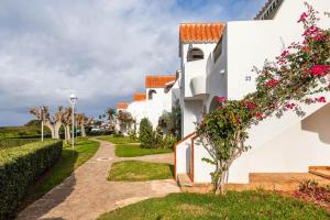 a white house with flowers on the side of it at Apartamento Lulu in Son Bou