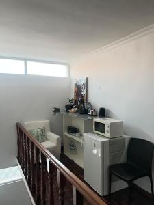 a balcony with a microwave and a chair at Pink House - Lisbon in Lisbon