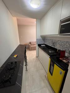 una cucina con un piano di lavoro nero e una stufa gialla di Flat Cln 216 Asa Norte By CentoEdez a Brasilia