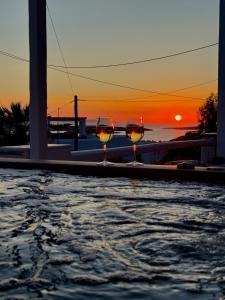 two glasses of wine sitting next to a swimming pool at La vie est belle luxury apartment BBQ jacuzzi&view in Pounda