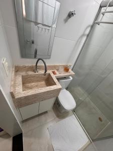un bagno con lavandino, WC e specchio di Flat Cln 216 Asa Norte By CentoEdez a Brasilia