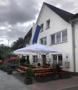 a building with tables and umbrellas in front of it at Apartment Ballova in Balve