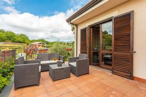 eine Außenterrasse mit Stühlen und einem Tisch in der Unterkunft Queen Etna - Beautiful Pool in Viagrande
