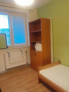 a bedroom with a bed and a cabinet and a window at Big House with beautiful city view, gym,BBQ garden and own parking in Žilina