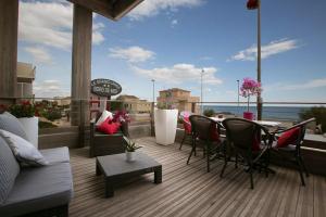d'une terrasse avec des chaises et une table sur un balcon. dans l'établissement Le Grand Large Bord de Mer Hotel & Appartements, à Palavas-les-Flots