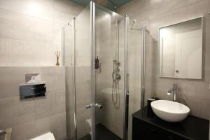 a bathroom with a glass shower and a sink at Domus Carmel Hotel in Haifa +41 photos