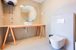 a bathroom with a sink and a toilet and a mirror at Pomalo apartments Vodice in Vodice +31 photos